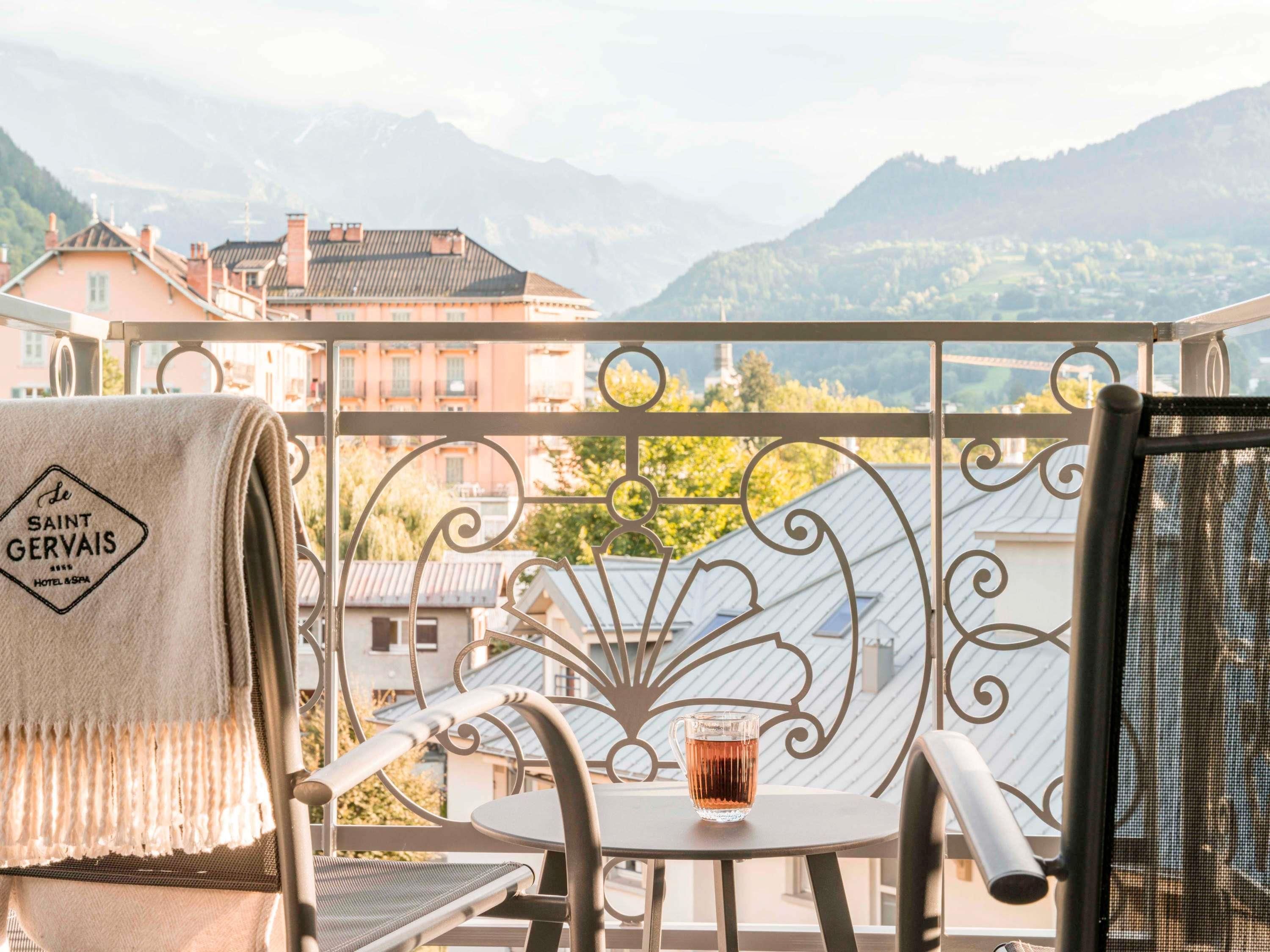 A balcony with a chair, a table, and a towel with 'Le Saint Gervais Hotel & Spa' text.