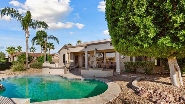 A residential property with a swimming pool, patio furniture, and a covered outdoor seating area. - SUMMER SPECIAL SUN CITY GRAND REMODLED HOME WITH POOL (Surprise)