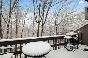 A snow-covered deck with a railing, a snow-covered table, and a propane tank. - Stay On The Mountain Under The Stars! (Tannersville)