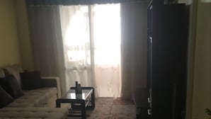 A living room with a sofa, a coffee table, and a television. - Apartment 450 metres from Playa del Cura (Torrevieja)