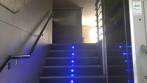 A staircase with blue LED lights, a handrail, and a sign indicating 24-hour availability. - Apartment 450 metres from Playa del Cura (Torrevieja)