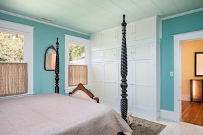 Quarto com cama, guarda-roupa espaçoso e espelho.