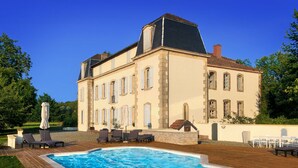 Un grand bâtiment doté d’une piscine, d’un espace extérieur aménagé et d’un jardin.