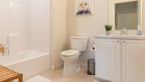Een moderne badkamer met een bad, toilet en wastafel.