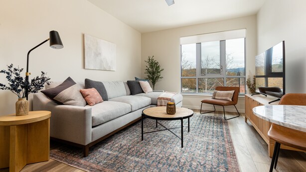 Een moderne woonkamer met een bank, salontafel en een eethoek.