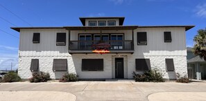 A two-story building with a balcony, a sign reading "Out of the Box," and a stone-textured facade.