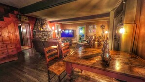 Un rincón de bar acogedor con barra de madera, asientos de cuero y una televisión.