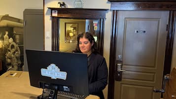 A reception desk with a computer, a welcome sign, and a door labeled 'Office'.