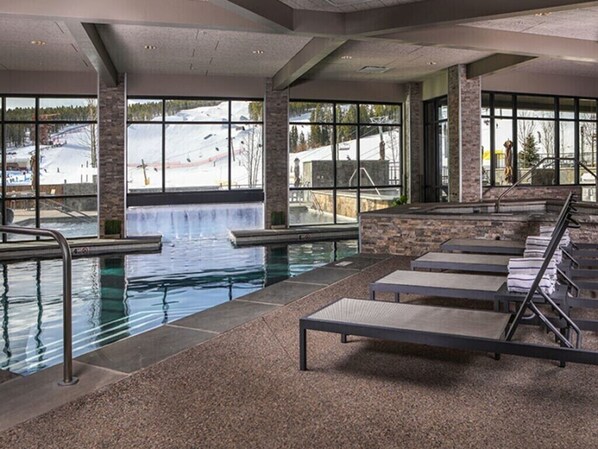 Relax by the pool with a view of the surrounding landscape through large windows.