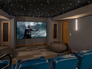 Enjoy movie nights in this cozy home theater room with a large flat-screen TV and comfortable seating.