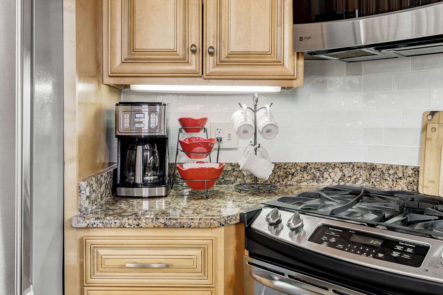 A kitchen with a coffee maker, a stove, and a microwave.