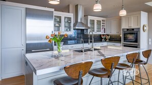 A modern kitchen with a large island, stainless steel appliances, and bar stools. - 3 bdrm, 3 bath Country Home, 10 acres, private, hot tub, view of Georgian Bay! (Bruce Peninsula (Wiarton) Thornbury)