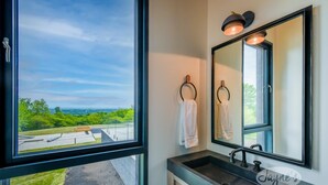 A bathroom with a large window, a modern sink, and two towels hanging on towel rings. - Lovely 5bdrm 3bath modern home in Creemore! (Creemore)