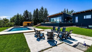 A modern house with a swimming pool, outdoor seating, and a covered patio area. - Lovely 5bdrm 3bath modern home in Creemore! (Creemore)