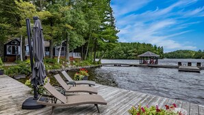 A wooden dock with lounge chairs and a gazebo by a lake. - 9 bdrm, 5 bath, Lake Rosseau, Private! Guest Cottage and Cabin! Sand Beach! (Port Carling)