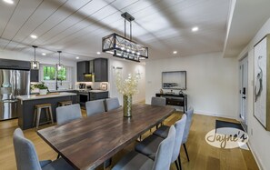 A modern kitchen with dark cabinets, stainless steel appliances, and a central island with seating.