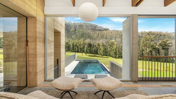 A modern interior with a large glass door leading to a pool and a view of a forested landscape. - Robinson's Run - The ultimate luxury country retreat (Kangaroo Valley)