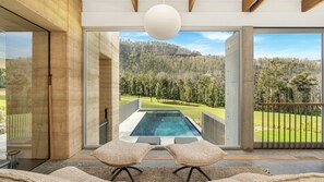 A modern interior with a large glass door leading to a pool and a view of a forested landscape. - Robinson's Run - The ultimate luxury country retreat (Kangaroo Valley)