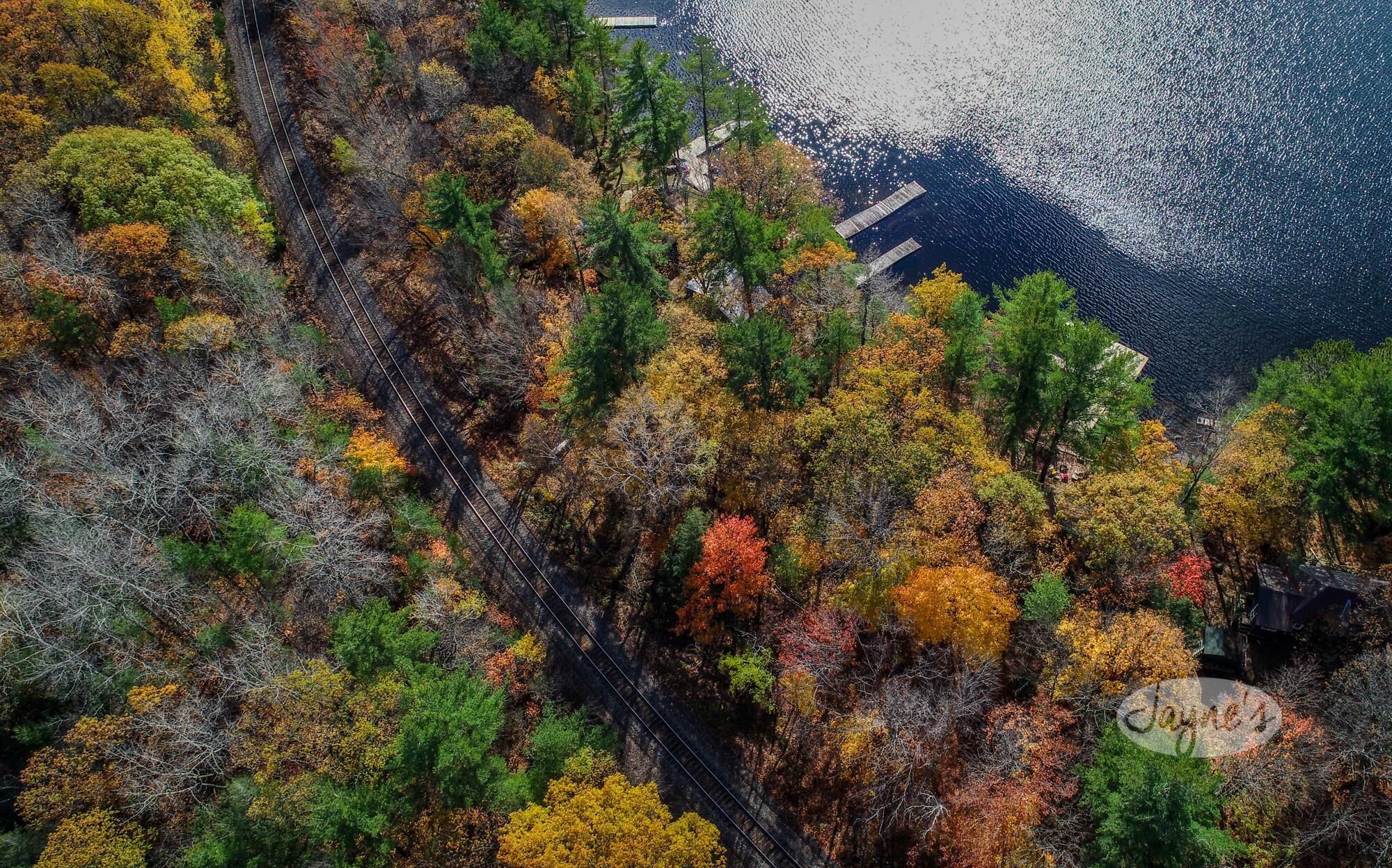 A mountainous landscape with autumn foliage and a railway track.