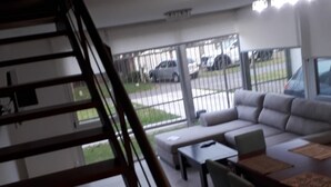 Ein modernes Wohnzimmer mit Treppe, einer Sofagarnitur, einem Couchtisch und einem Esstisch.