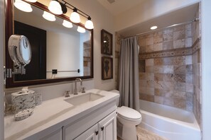 A bathroom with a large mirror, a sink, a toilet, and a shower. - Ironwood by Luxury Mountain Destinations (Park City)