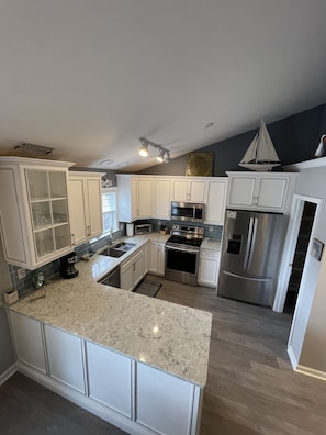 Enjoy cooking in this well-equipped kitchen with a central island, stainless steel appliances, and ample cabinetry.