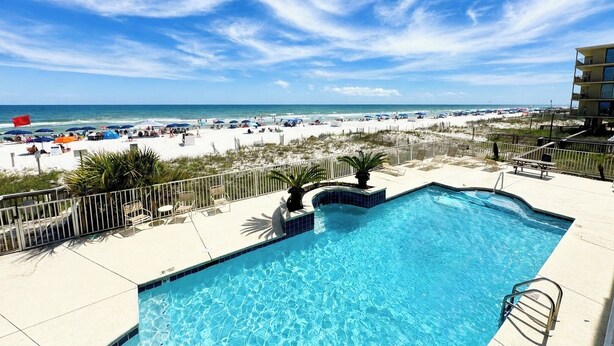 A swimming pool with a view of the beach and ocean.