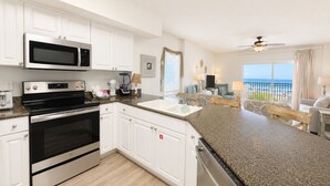 A modern kitchen with white cabinets, a microwave, an oven, and a dishwasher.