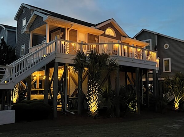 Stunning two-story residence with a spacious balcony and gabled roof, set amidst beautifully maintained gardens.