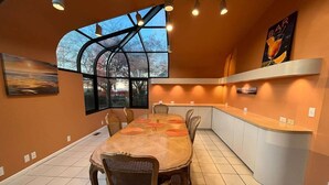 Una cocina moderna con una mesa grande, sillas y una zona de bar.