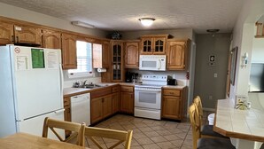 A kitchen with wooden cabinets, a microwave, a stove, and a dishwasher. - Porch sunset on the lake, 1/2 mile from Beaver Creek Marina! (Monticello)