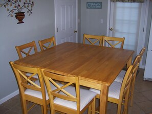 A dining room with a wooden table and six chairs.