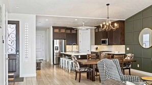 A spacious kitchen with dark wooden cabinets, a central island, and modern appliances. - Desert Moose #75 by RedAwning (Ivins)