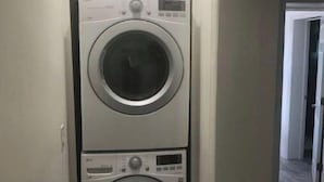 Une buanderie équipée de deux machines à laver à chargement frontal superposées.