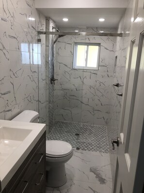 Een douche, een haardroger, handdoeken, toiletpapier