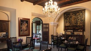 Un coin repas agrémenté d’un lustre, d’une grande tapisserie et d’un buffet en bois traditionnel.