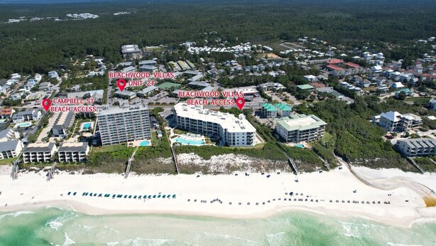 Luchtbeeld van Beachwood Villas met meerdere gebouwen, een strand en een bebost gebied.