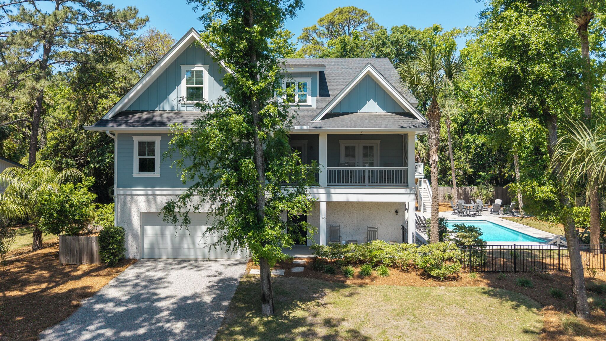 A two-story house with a front porch, a garage, and a swimming pool.