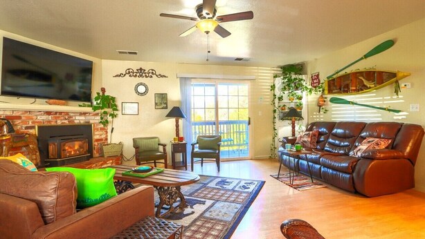 A living room with a fireplace, leather sofa, and a television. -  Spacious- 11 min to Yosemite toll- 13 guests- 7+ beds, pet- game room- 2000 Ft (Oakhurst)