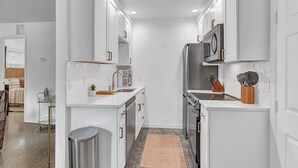 A modern kitchen with white cabinetry, stainless steel appliances, and a granite countertop. - 3-bedroom-2 Full Baths Beach House mnts to Central Beach & downtown (Vero Beach)