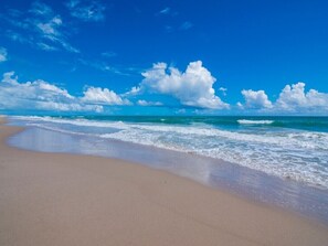 Ein Strand mit blauem Himmel und Wellen.