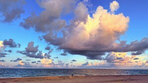 A beach with a clear sky and clouds.