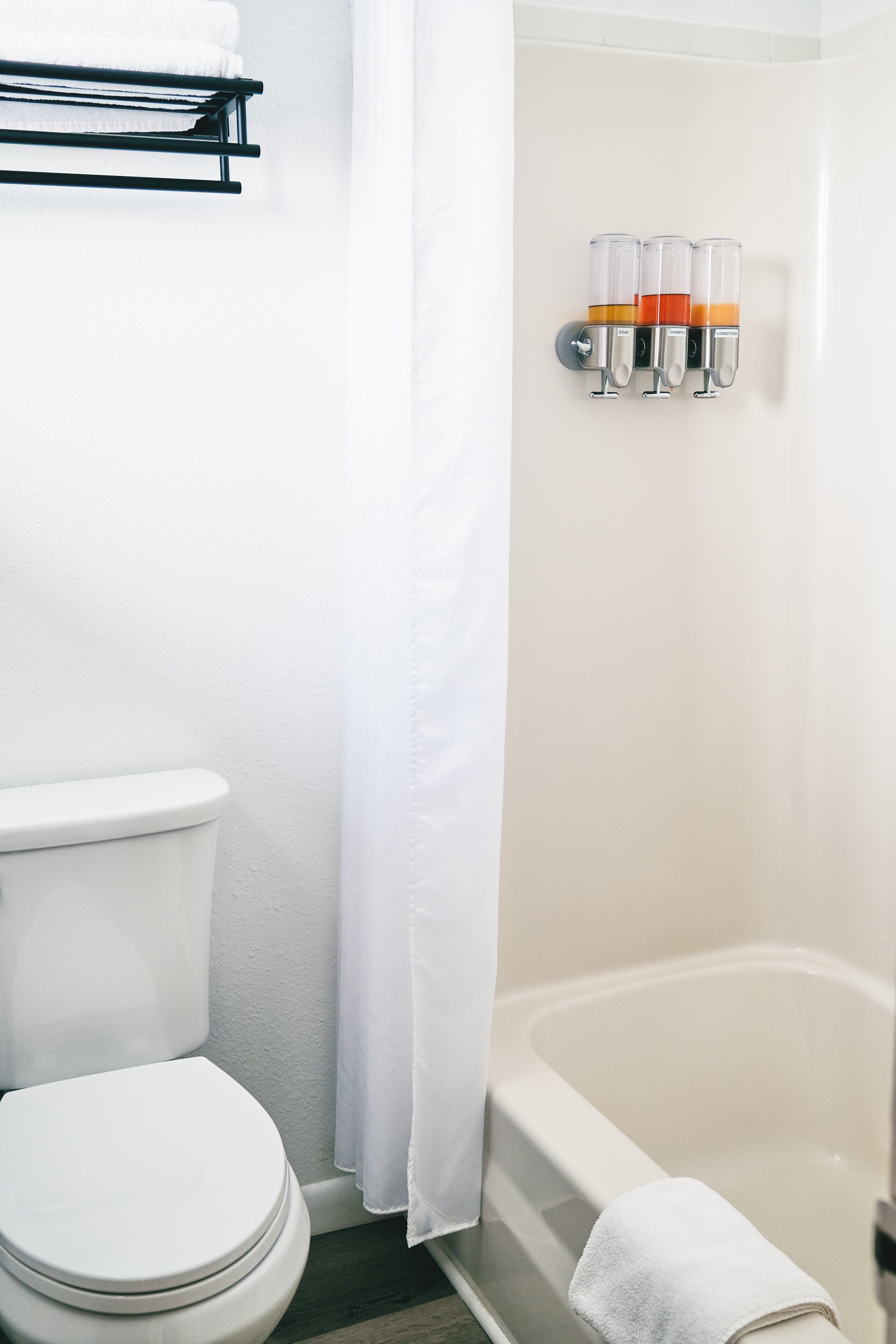 Een badkamer met toilet, bad en douchegordijn.