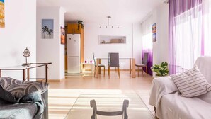Una sala de estar moderna con un sofá, una mesa de centro y un comedor con sillas y una mesa.