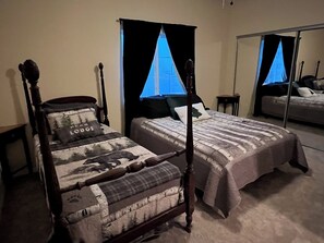 Relax in a serene bedroom with a four-poster bed, large mirror, and sofa bed.