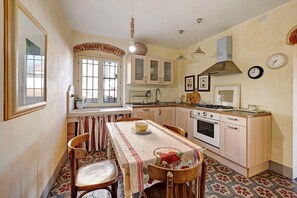 Una cocina con una mesa de comedor, sillas, estufa, horno y lavaplatos.