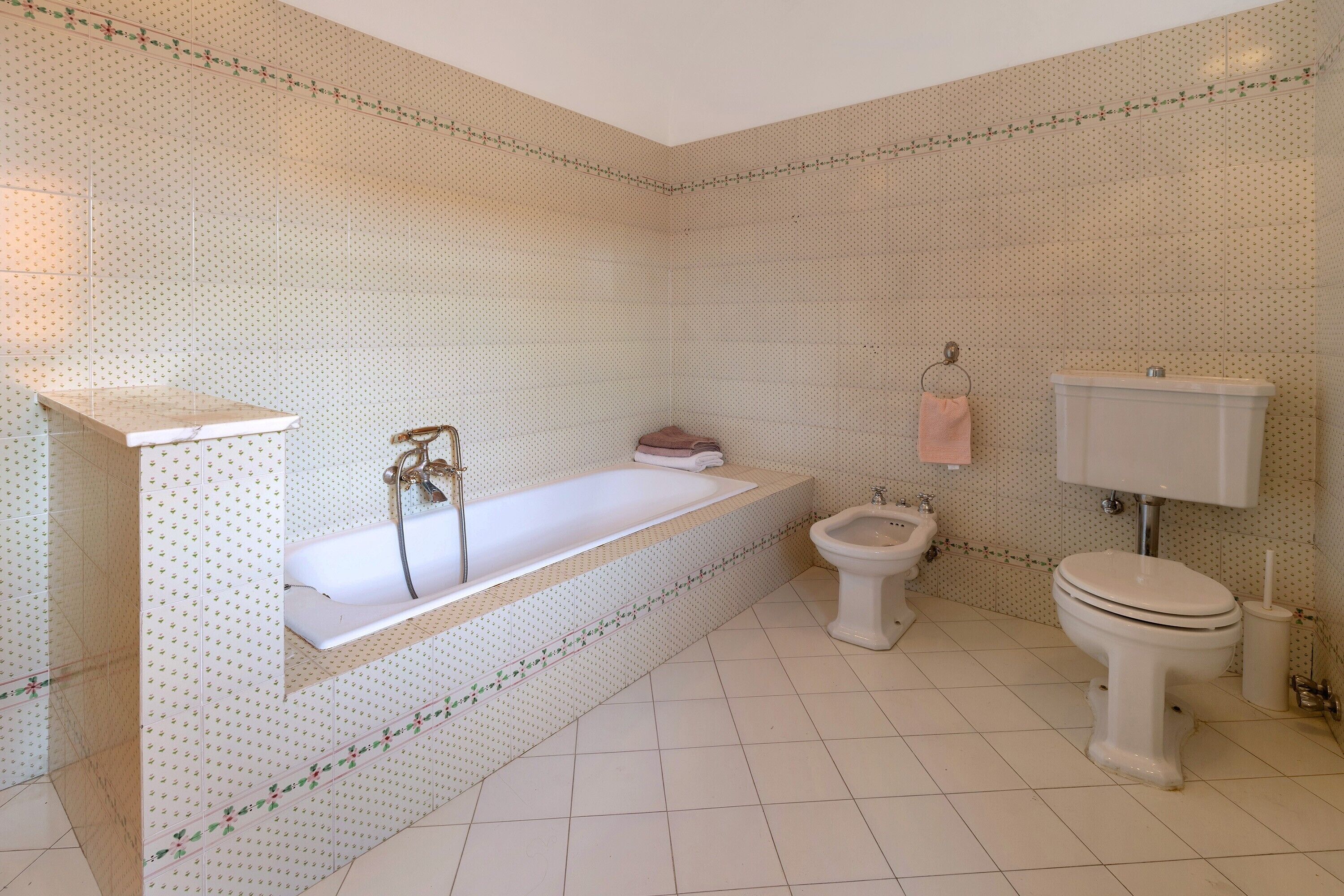 A bathroom with a freestanding bathtub, a toilet, and a bidet.