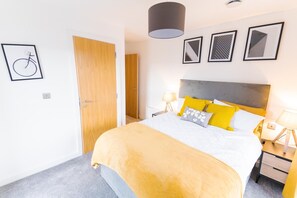 Une chambre à coucher moderne avec un lit, des tables de chevet et une porte.
