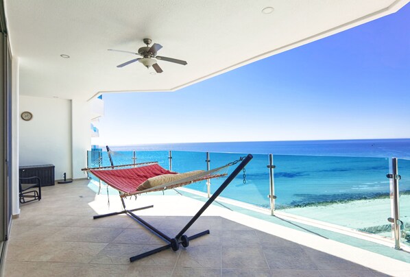 A balcony with a hammock, a ceiling fan, and a view of the ocean. - Hotel Esmeralda Beach Resort (Puerto Peñasco)