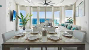 A dining area with a view of the ocean, a ceiling fan, and a sofa with cushions. - Hotel Esmeralda Beach Resort (Puerto Peñasco)